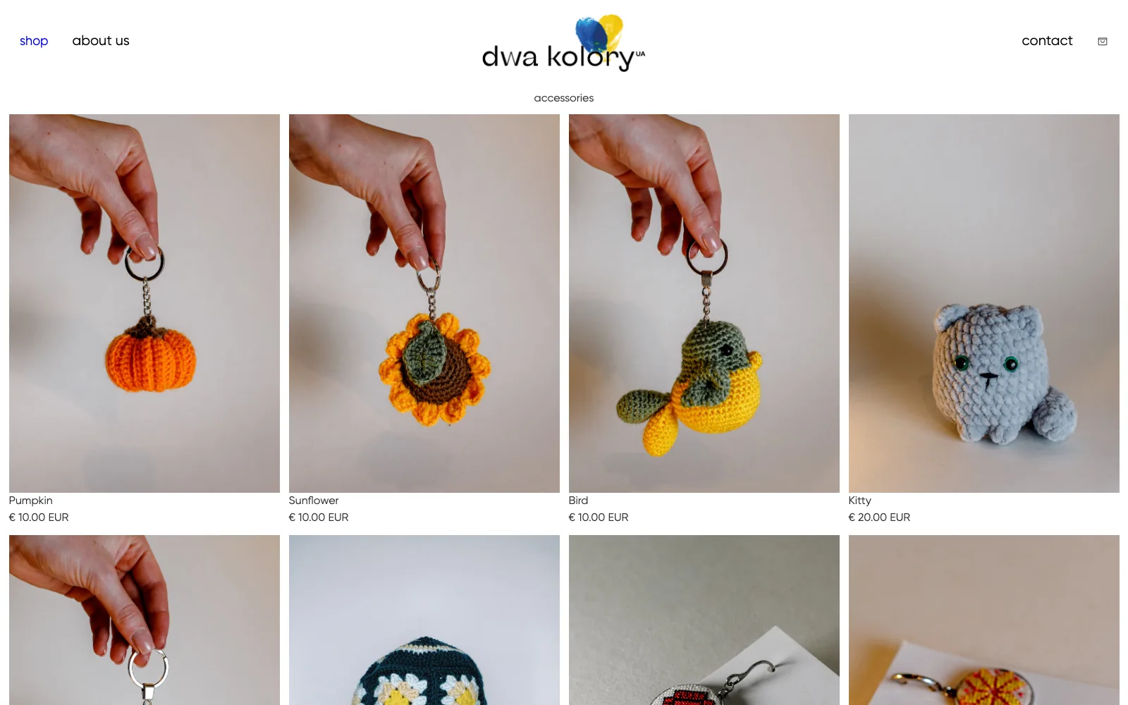 Dwa Kolory desktop accessories category grid of crochet keychains, including a pumpkin, sunflower, bird, and cat, each with its price.