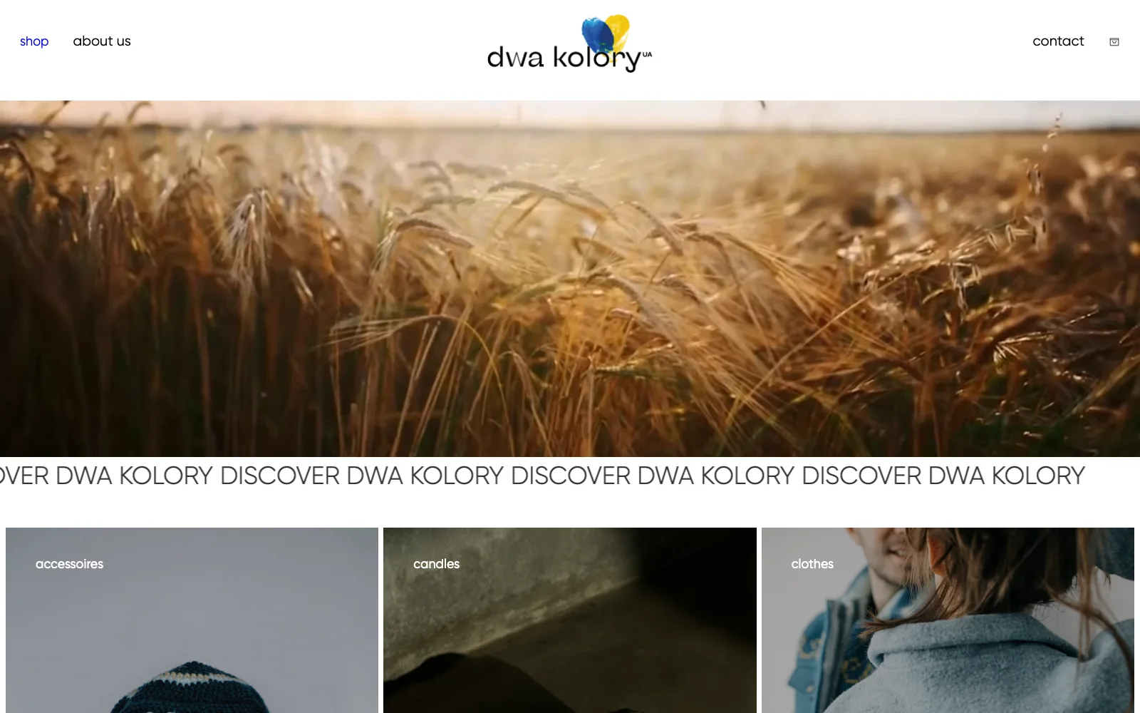 Dwa Kolory desktop homepage with a wheat field hero photo and a category row for accessories, candles, and clothes.